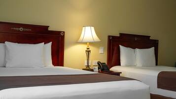 A hotel room with two beds, a bedside lamp, a phone, and a nightstand.