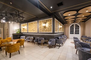 Un interior moderno con mostrador de recepción, zona de estar y paneles decorativos en el techo.