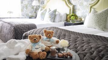 Relax in a classic bedroom with a large tufted bed, adorned with a white rose and a teddy bear.