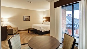 A hotel room with a bed, bedside table, lamp, chair, and a view of the outside. - Best Western London Airport Inn & Suites (London)