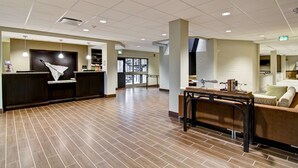 A spacious lobby with a reception desk, a seating area, and a view of the outside. - Best Western London Airport Inn & Suites (London)
