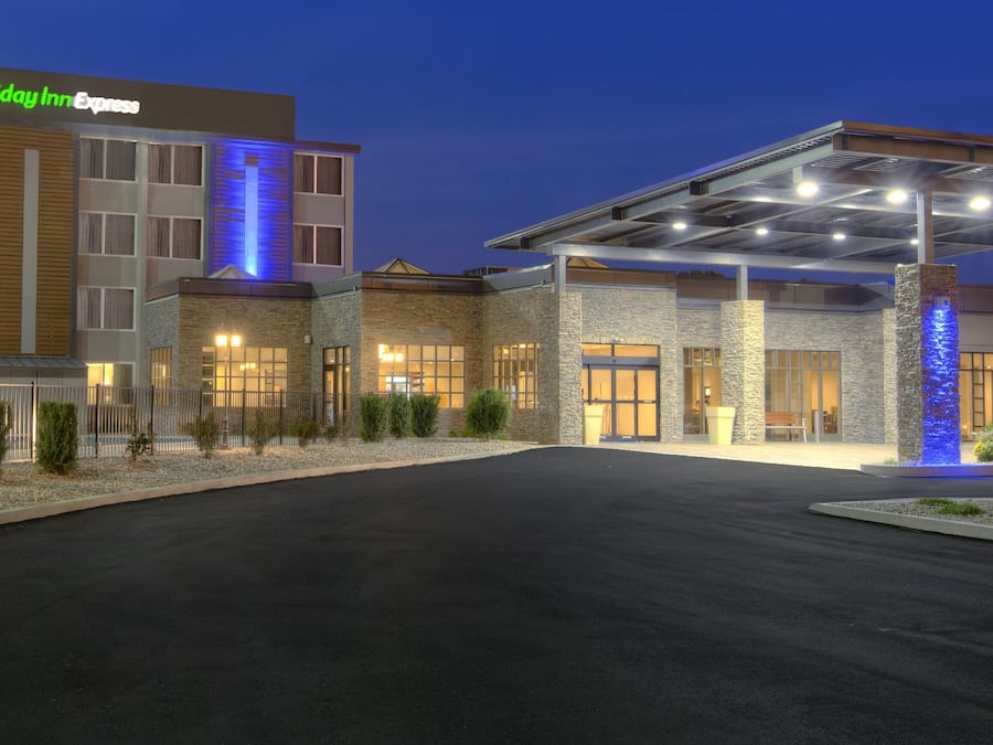 A Holiday Inn Express hotel with a covered parking area and a well-lit facade.