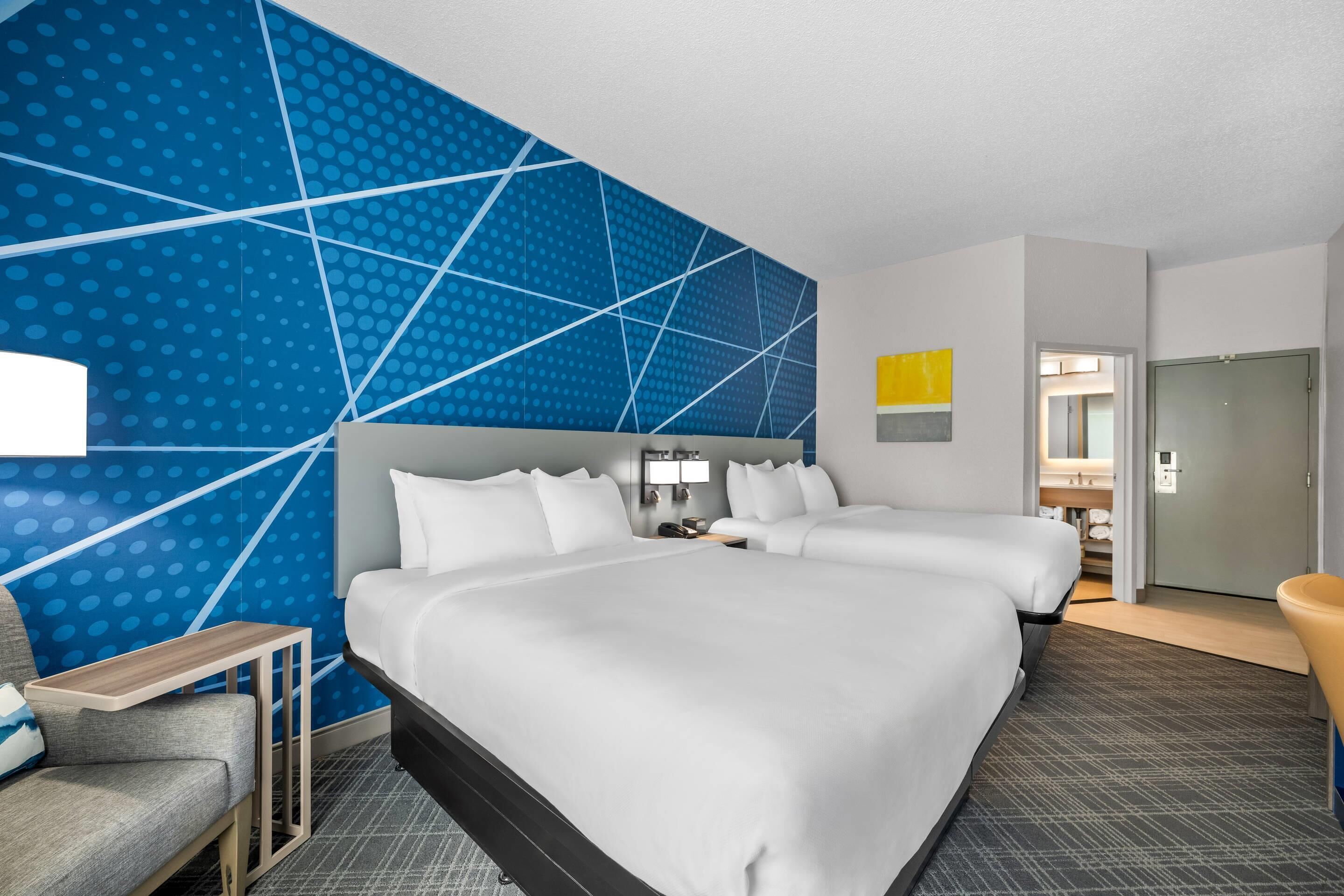 Een hotelkamer met een groot bed, een bureau, een stoel en een badkamer.