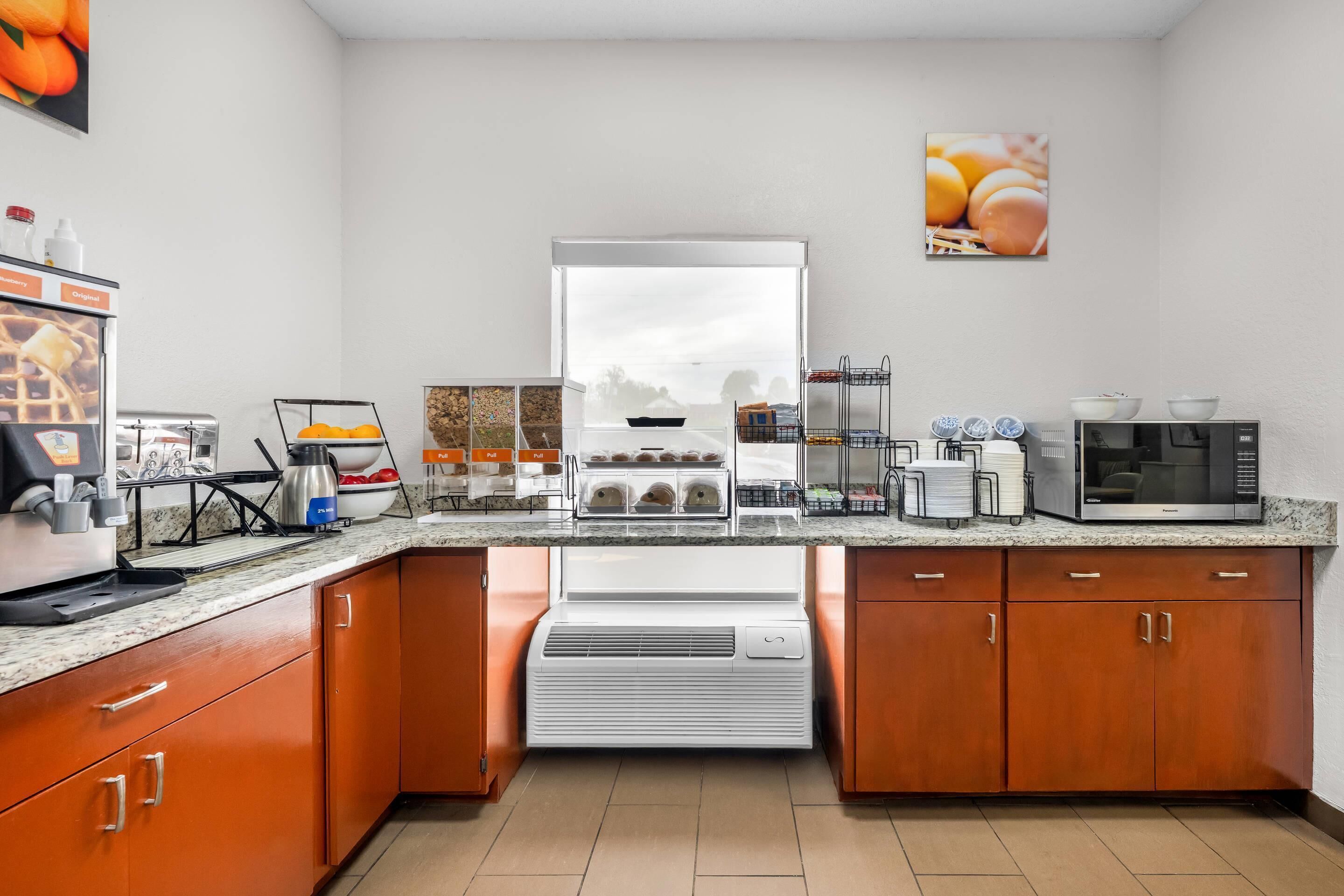 A modern kitchen with a built-in air conditioning unit, a coffee station, and a microwave.