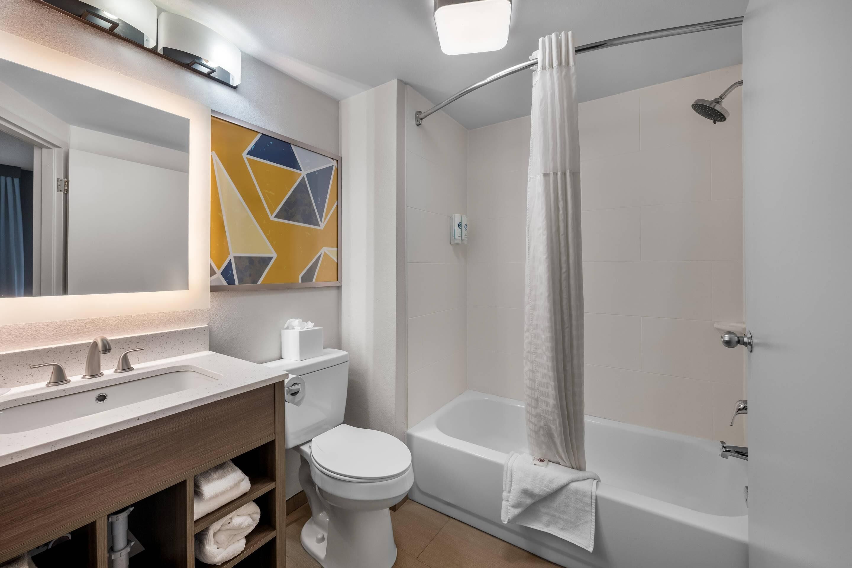 Een moderne badkamer met een wastafel, toilet en bad.