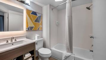 Een moderne badkamer met een wastafel, toilet en bad.
