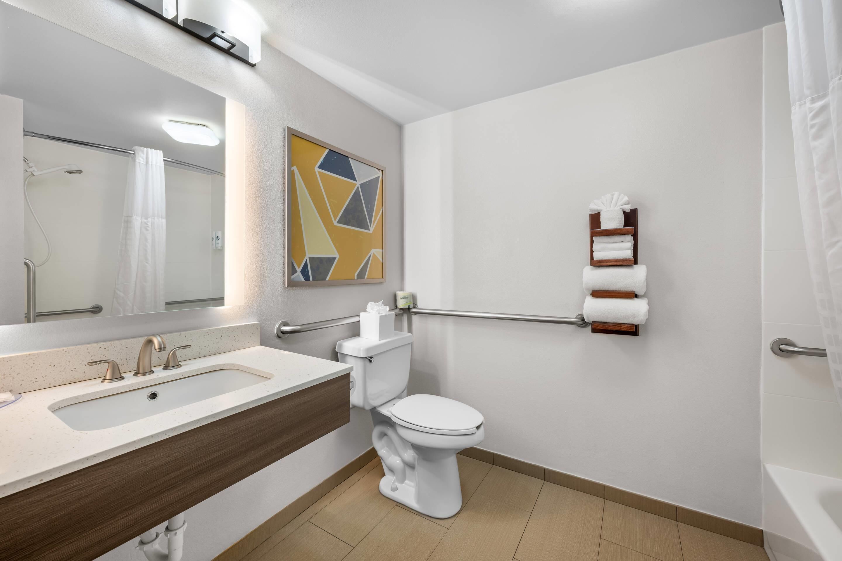 A modern bathroom with a sink, toilet, and shower.