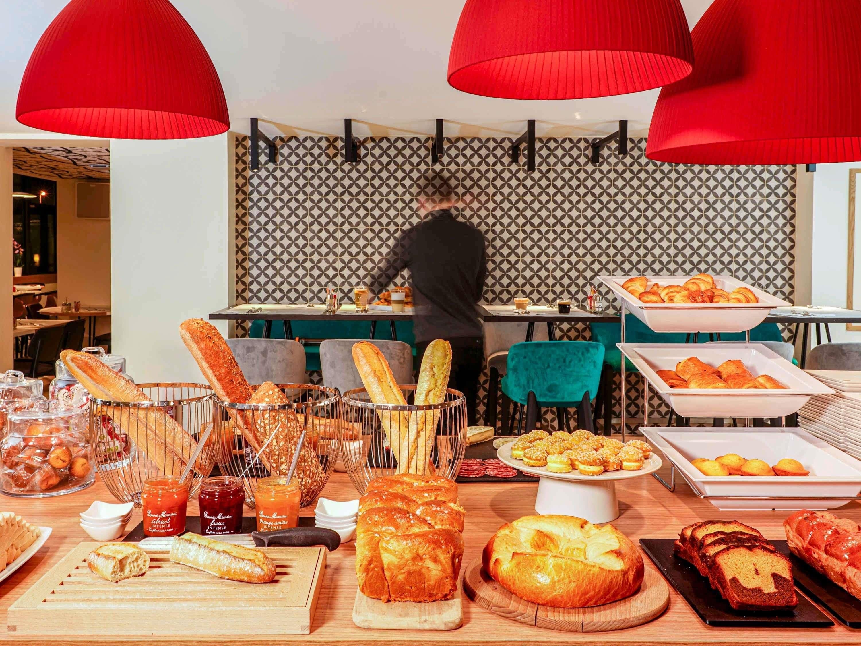 Un bufé de desayuno con panes, pasteles y salsas diversas.