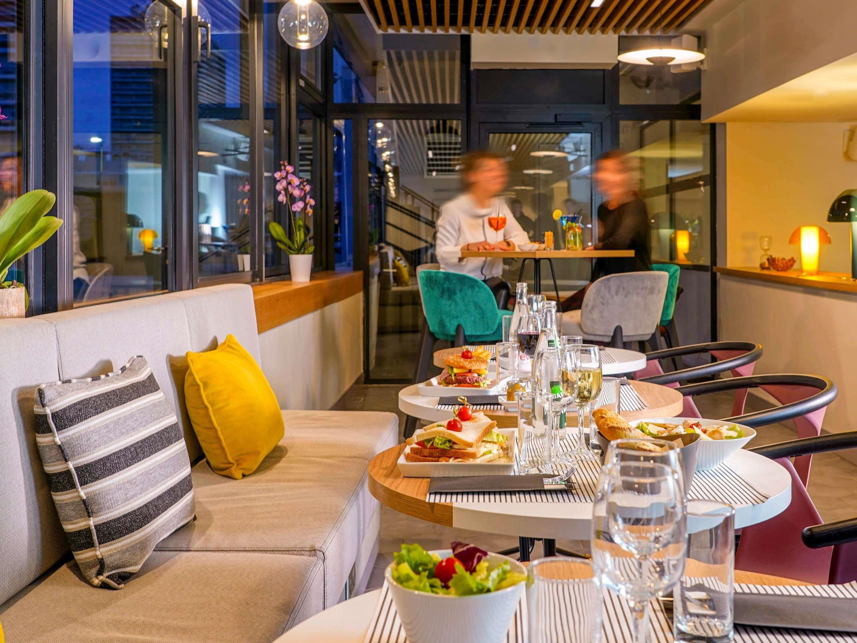 Un comedor moderno con sofá, mesa, sillas y vistas a la ciudad.