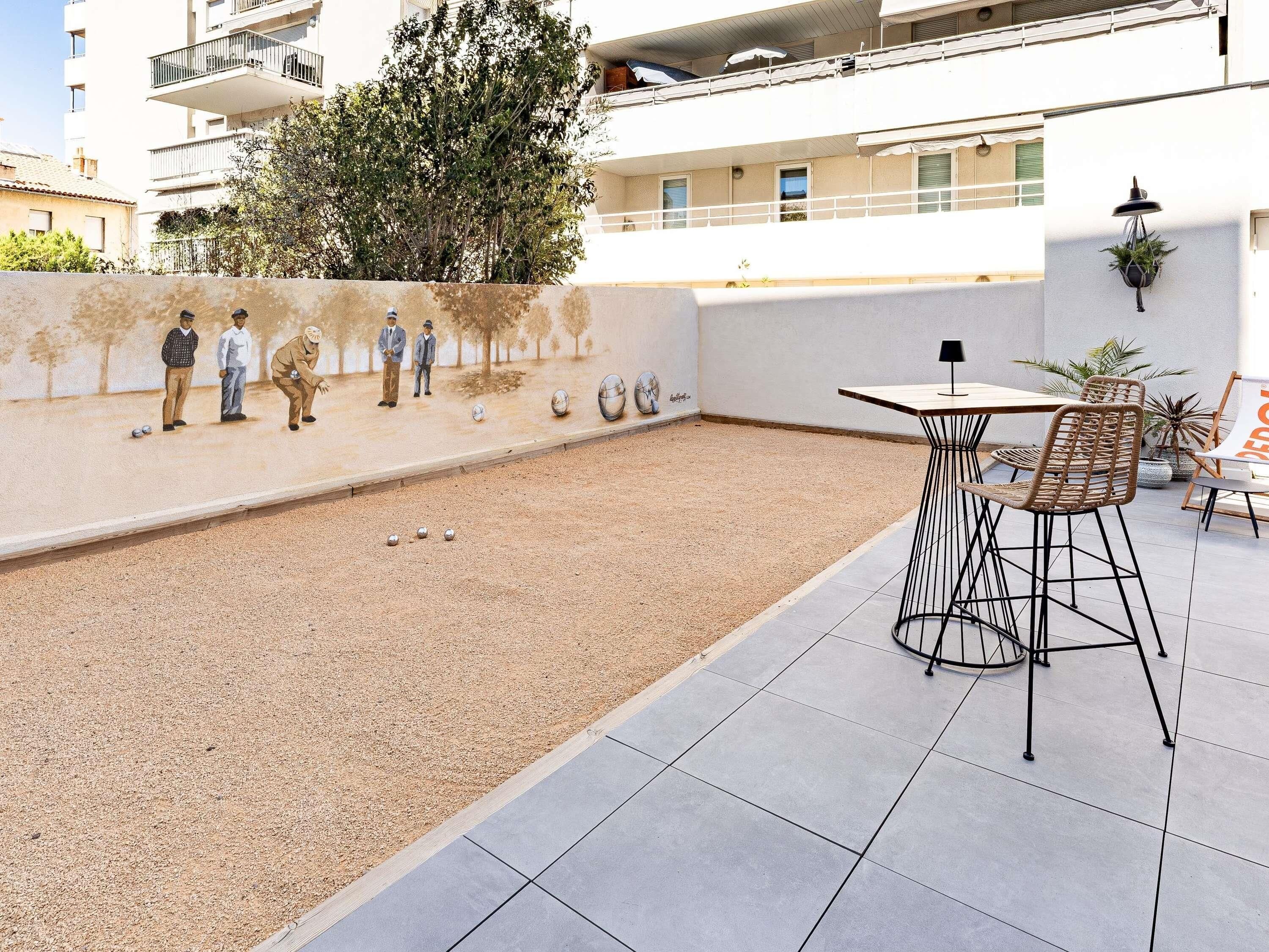 Un patio con mesa de billar, sillas y un mural.