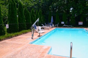 A swimming pool with lounge chairs and a lifeguard stand. - Rodeway Inn (Lynchburg)