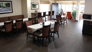 A restaurant with booths and tables, a refrigerator, and a microwave.