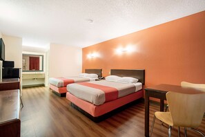 A hotel room with two beds, a wooden desk, a chair, and a TV. - Motel 6 Covington, TN (Covington)
