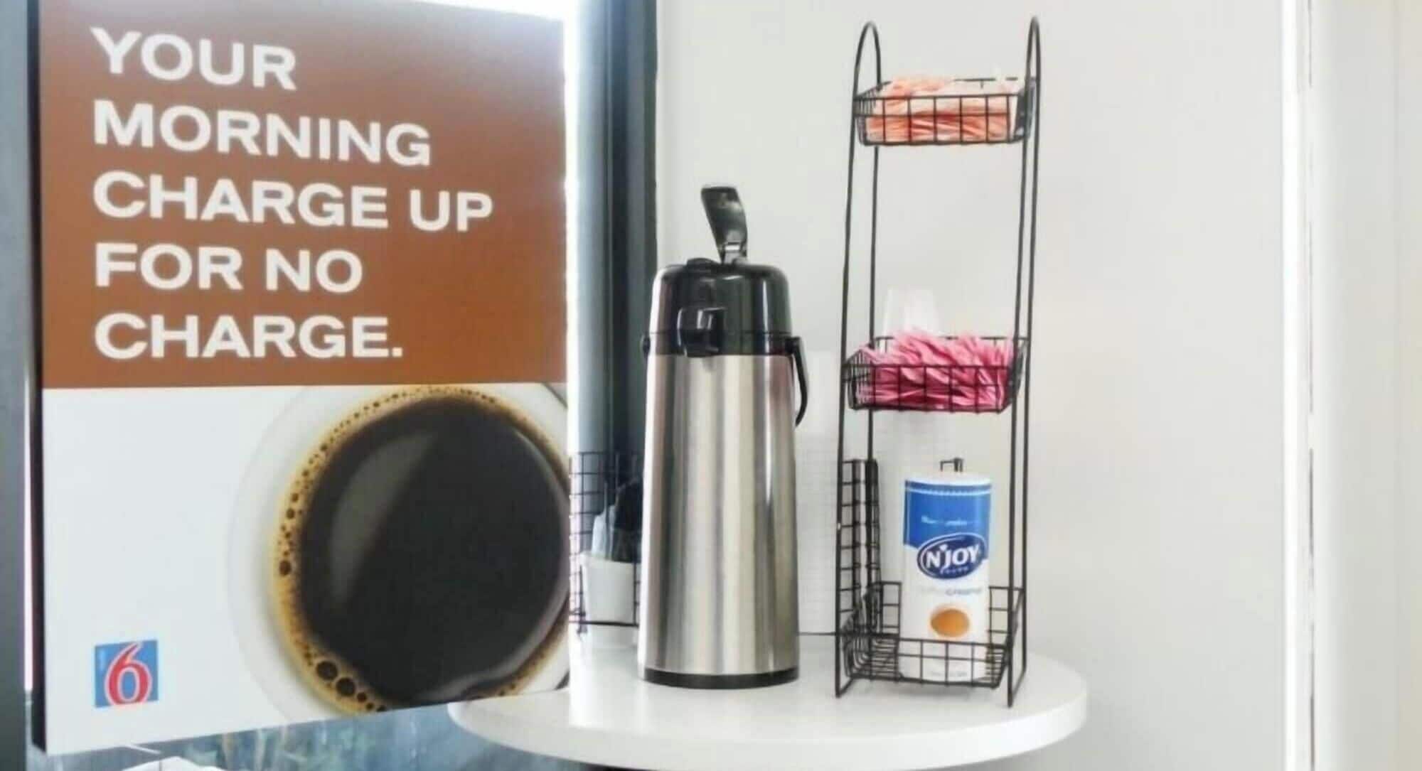 Una cafetera, una cápsula de café Njoy y un cartel con un mensaje sobre recargar sin costo.