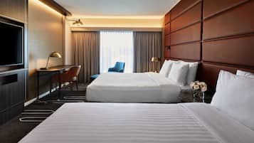 Ein Hotelzimmer mit einem großen Bett, einem Schreibtisch, einem Stuhl und einem Fernseher.