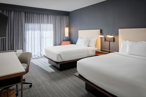 A hotel room with two beds, a desk, and a chair. - Courtyard by Marriott Manassas Battlefield Park (Manassas)