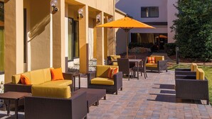 An outdoor patio area with wicker furniture, including sofas and chairs, and a table.