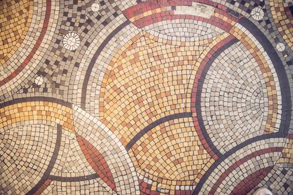 Un detallado suelo de mosaicos con diseños circulares y pequeños elementos decorativos.