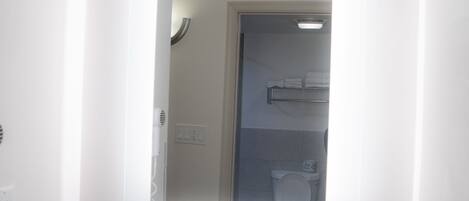 A bathroom with a sink, a mirror, a coffee maker, and a towel rack.