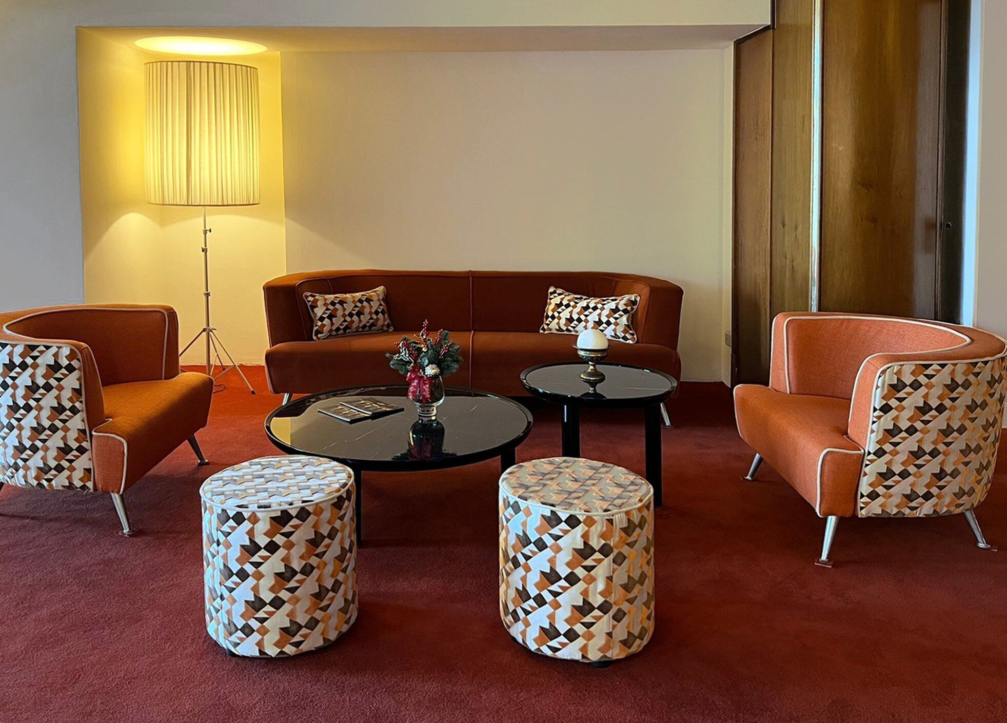 A modern living room with a sofa, two armchairs, a coffee table, and a floor lamp.