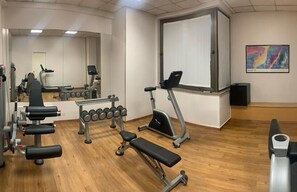 Work out in style with a fully equipped gym featuring exercise machines, free weights, and a wall-mounted TV.