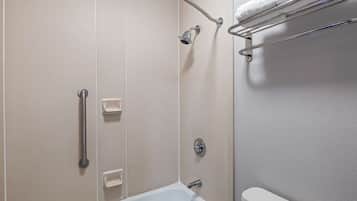 A bathroom with a shower, grab bars, a towel rack, and a toilet.