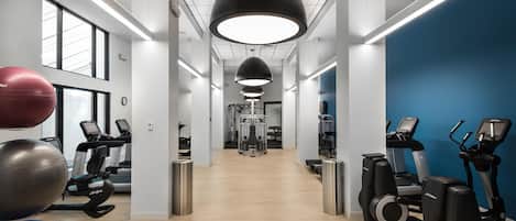 A gym with treadmills, exercise balls, and weight machines.