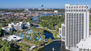 Un resort con varias piscinas, una extensa masa de agua y un edificio de gran altura.