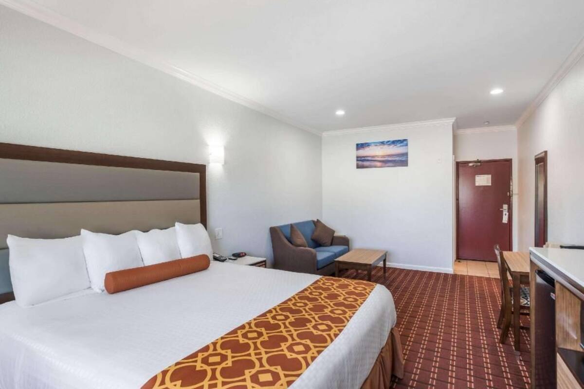 Een hotelkamer met een groot bed, een bureau, een stoel en een klein tafeltje.