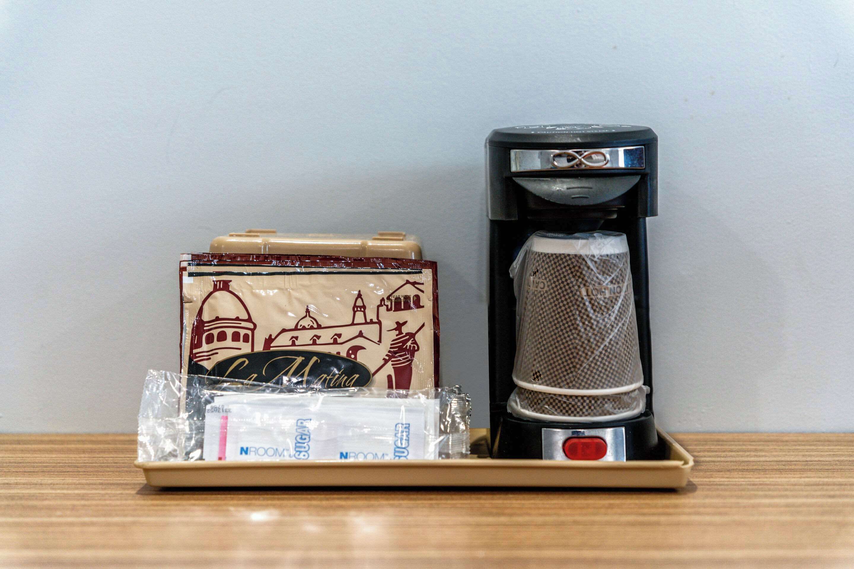 A coffee maker and a travel-sized espresso machine on a tray.