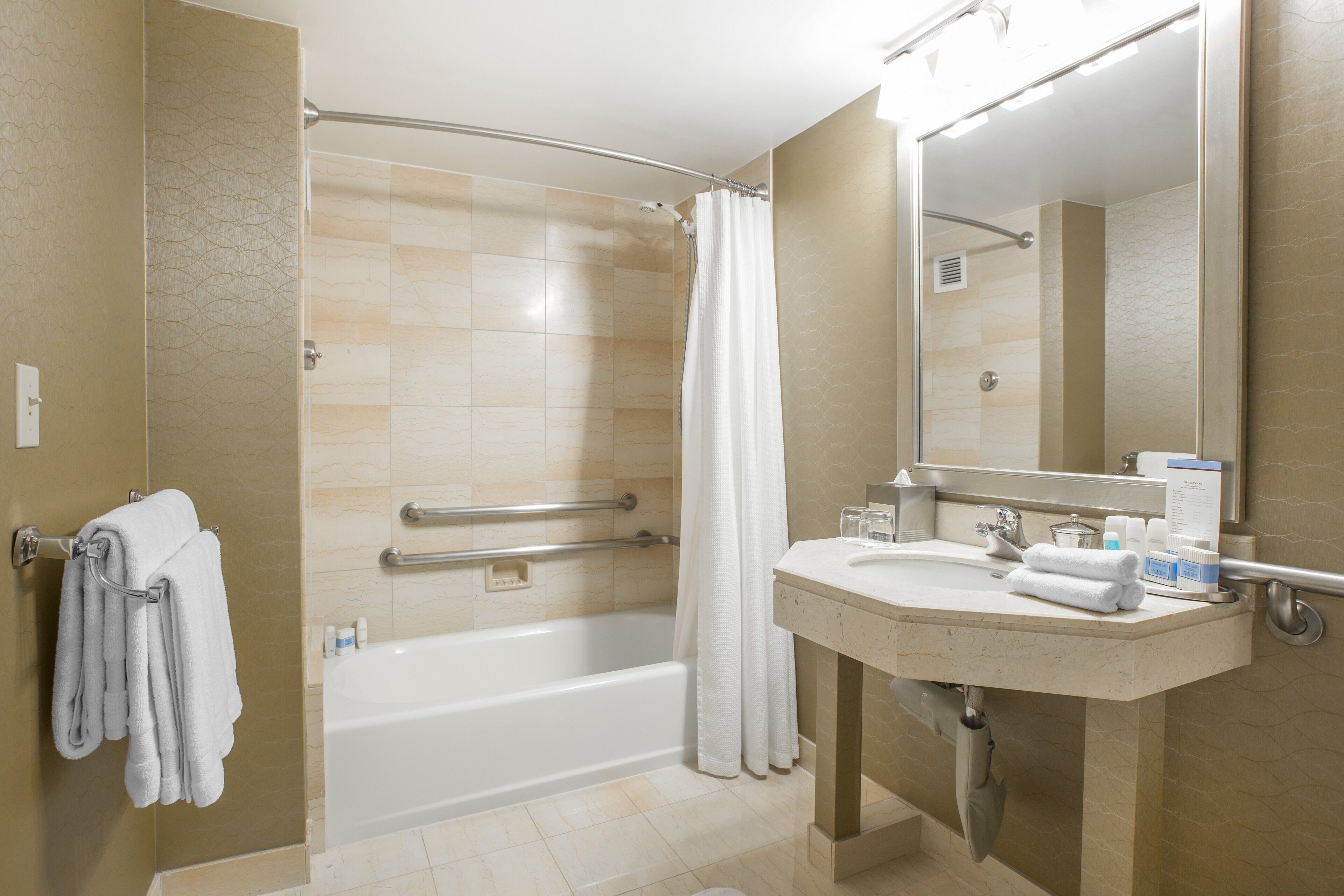 A modern bathroom with a bathtub, shower, and sink.