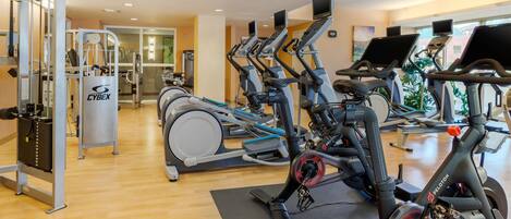 A gym with stationary bikes, a Cybex machine, and a Peloton bike.