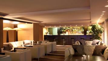 A hotel lobby with seating areas, a bar, and a reception desk.