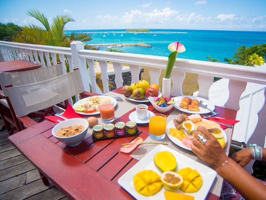 Ett matbord med frukostmat och utsikt över havet.
