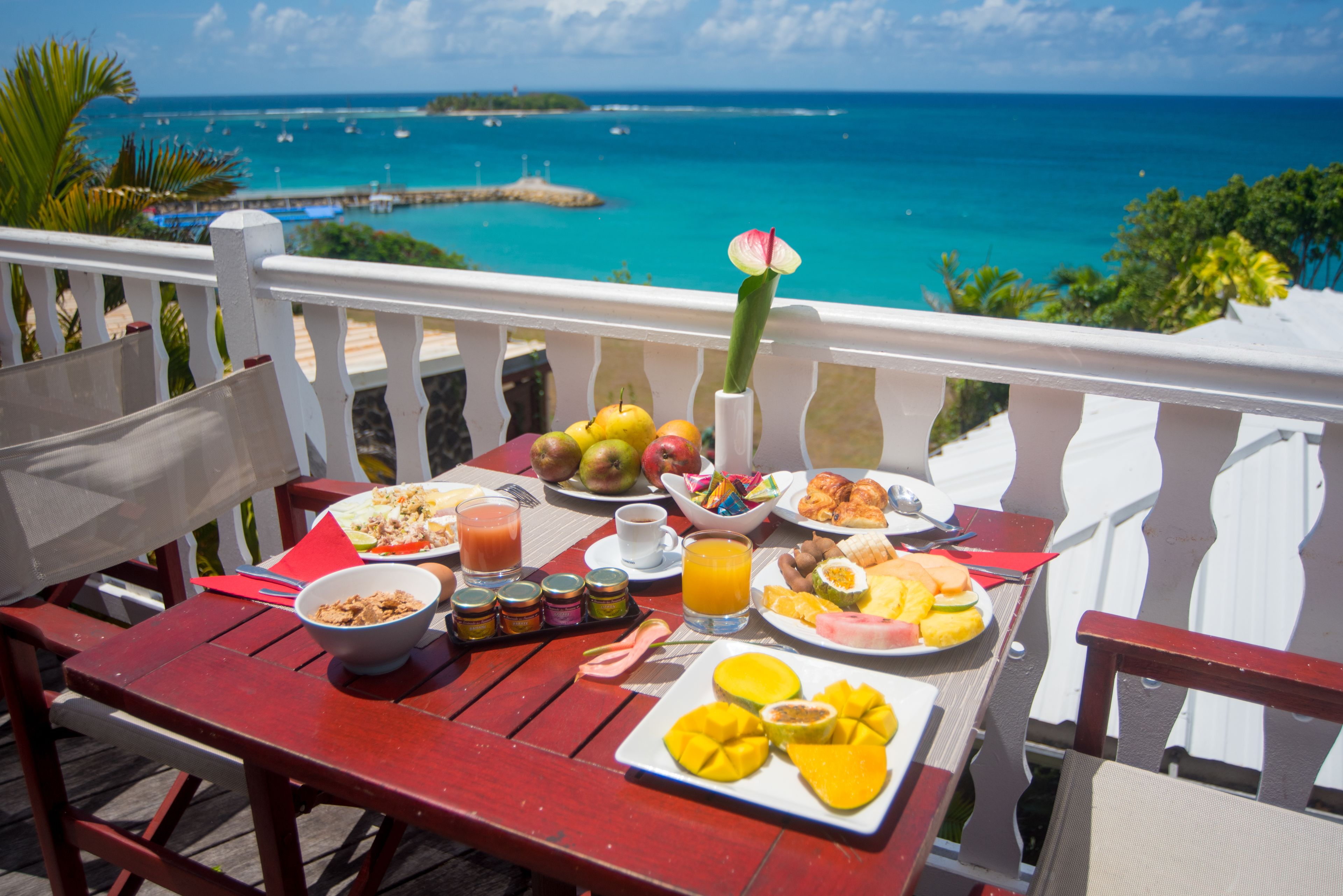 A table with breakfast items and a view of the ocean.