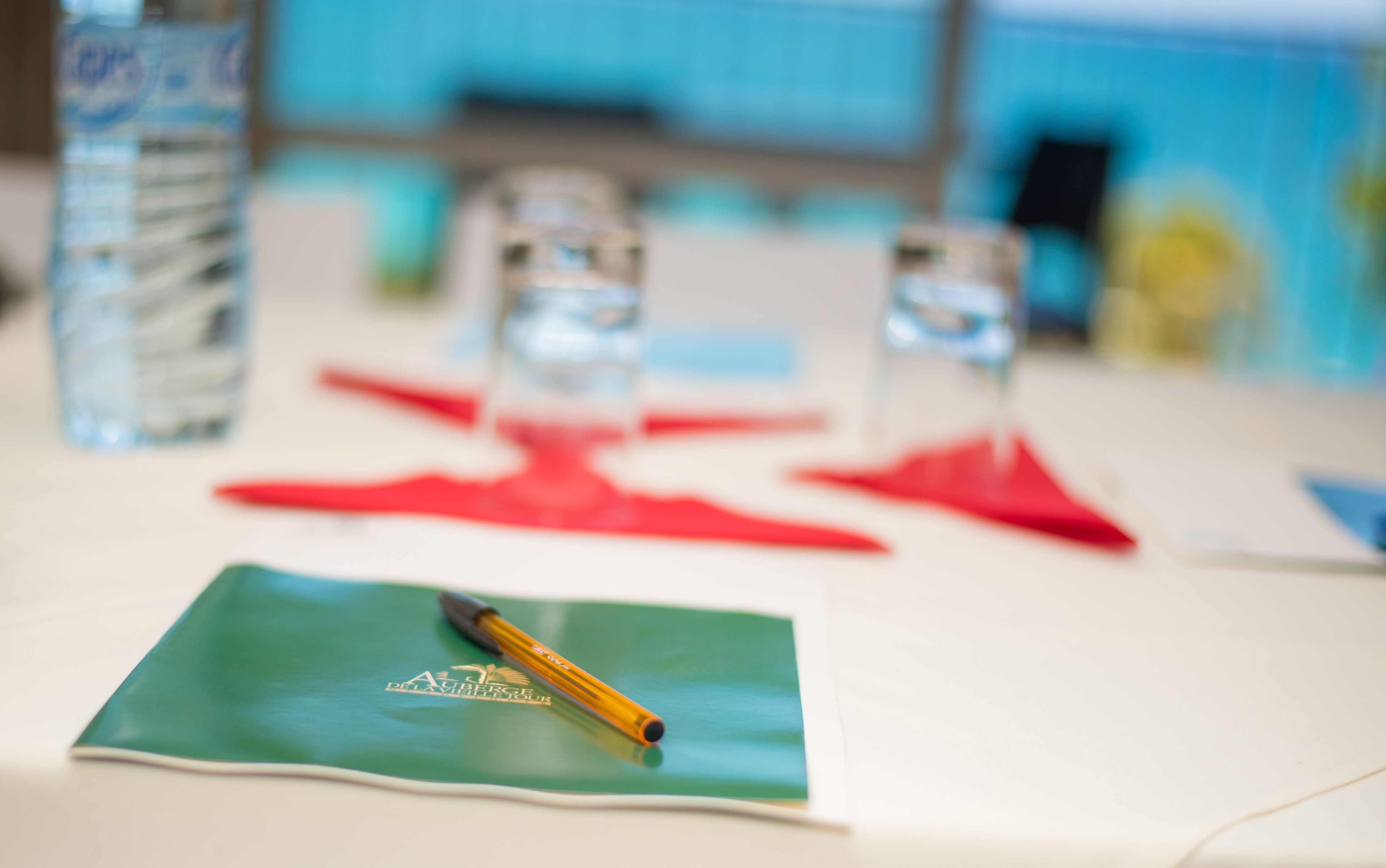 A table with a green placemat, a yellow pen, and red napkins.
