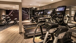Un gimnasio con cintas de correr, elípticas y máquinas de pesas.