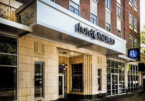 Hotel Indigo with a modern facade, large windows, and a prominent sign.