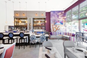 Een modern café met een bar en zitplaatsen, een toonbank met diverse drankjes en een groot raam met uitzicht op de straat.