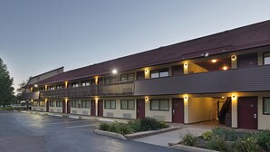 A multi-story motel with a parking lot in front. - Red Roof Inn Lansing West - MSU (Lansing)