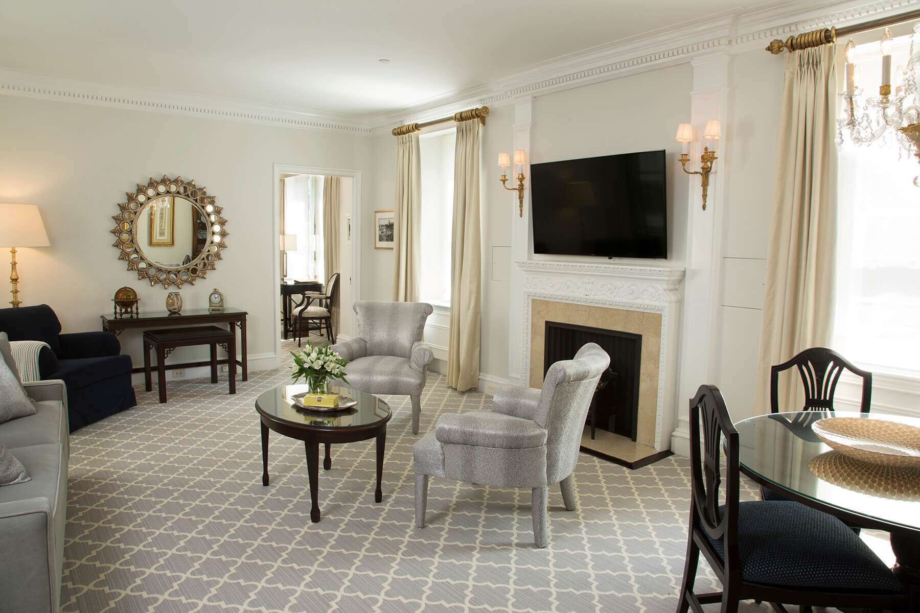 A spacious living room with a fireplace, a television, and a dining area with a glass table.