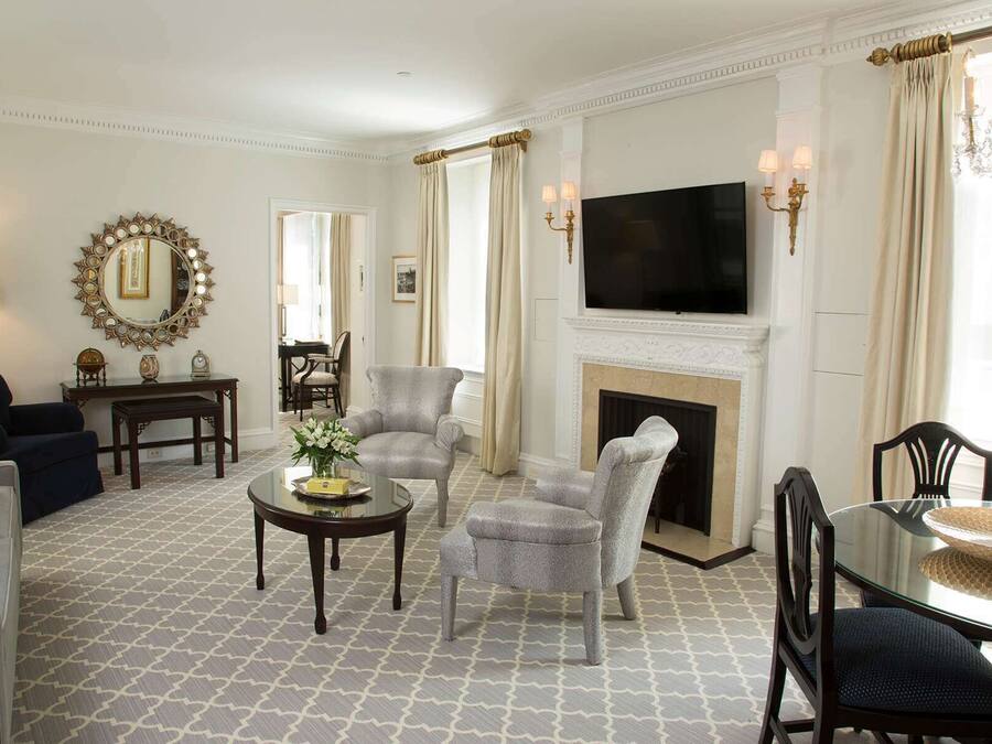 A spacious living room with a fireplace, a television, and a dining area with a glass table.