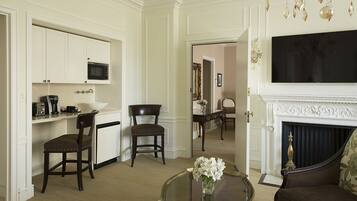 A living room with a fireplace, a television, and a dining area with a microwave.