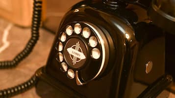 A vintage black rotary dial telephone with a 'Lobby' label on the dial.
