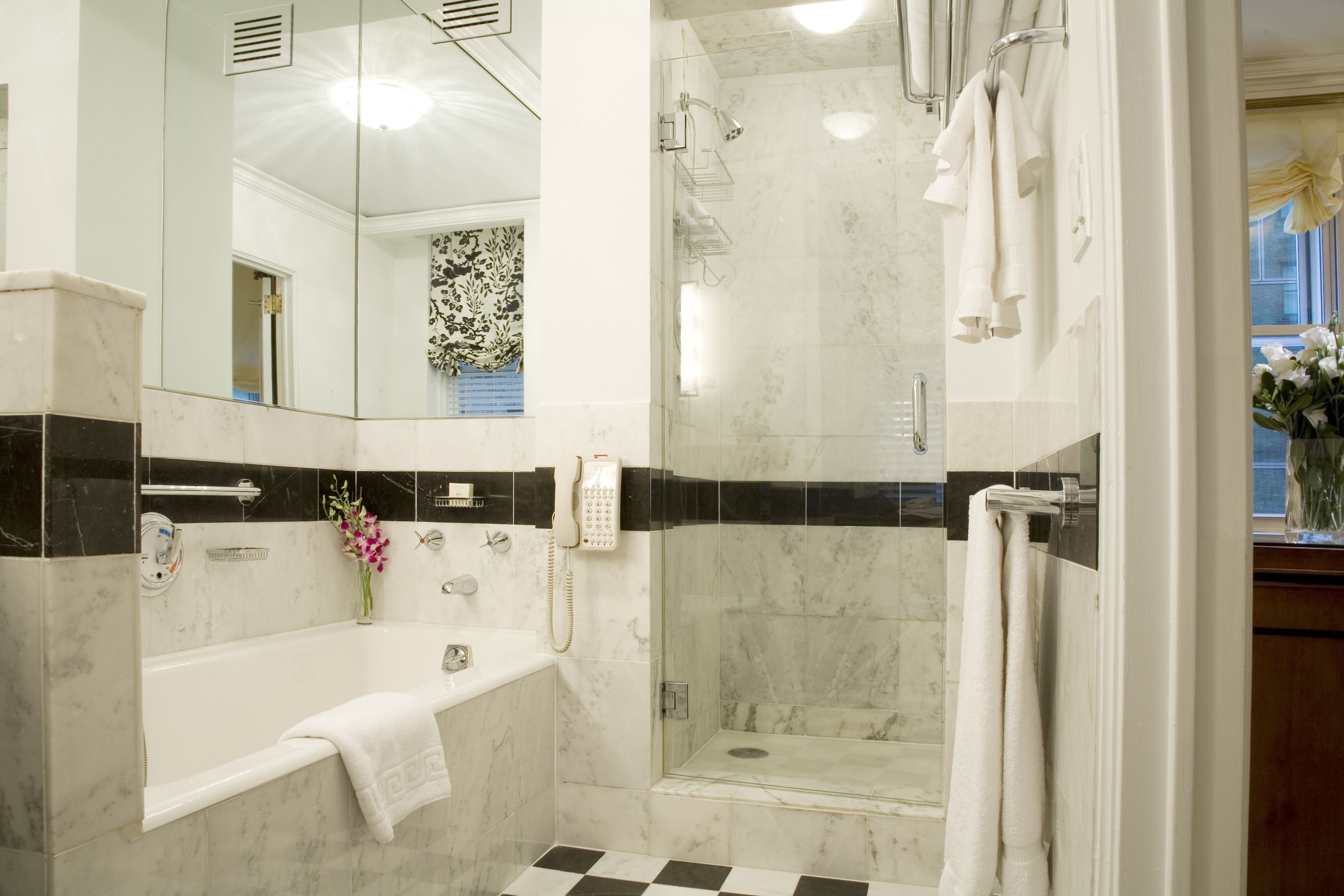 Un baño moderno con bañera, ducha y cabina de ducha con paredes de vidrio.