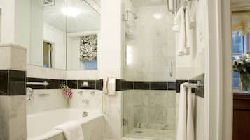 Un baño moderno con bañera, ducha y cabina de ducha con paredes de vidrio.