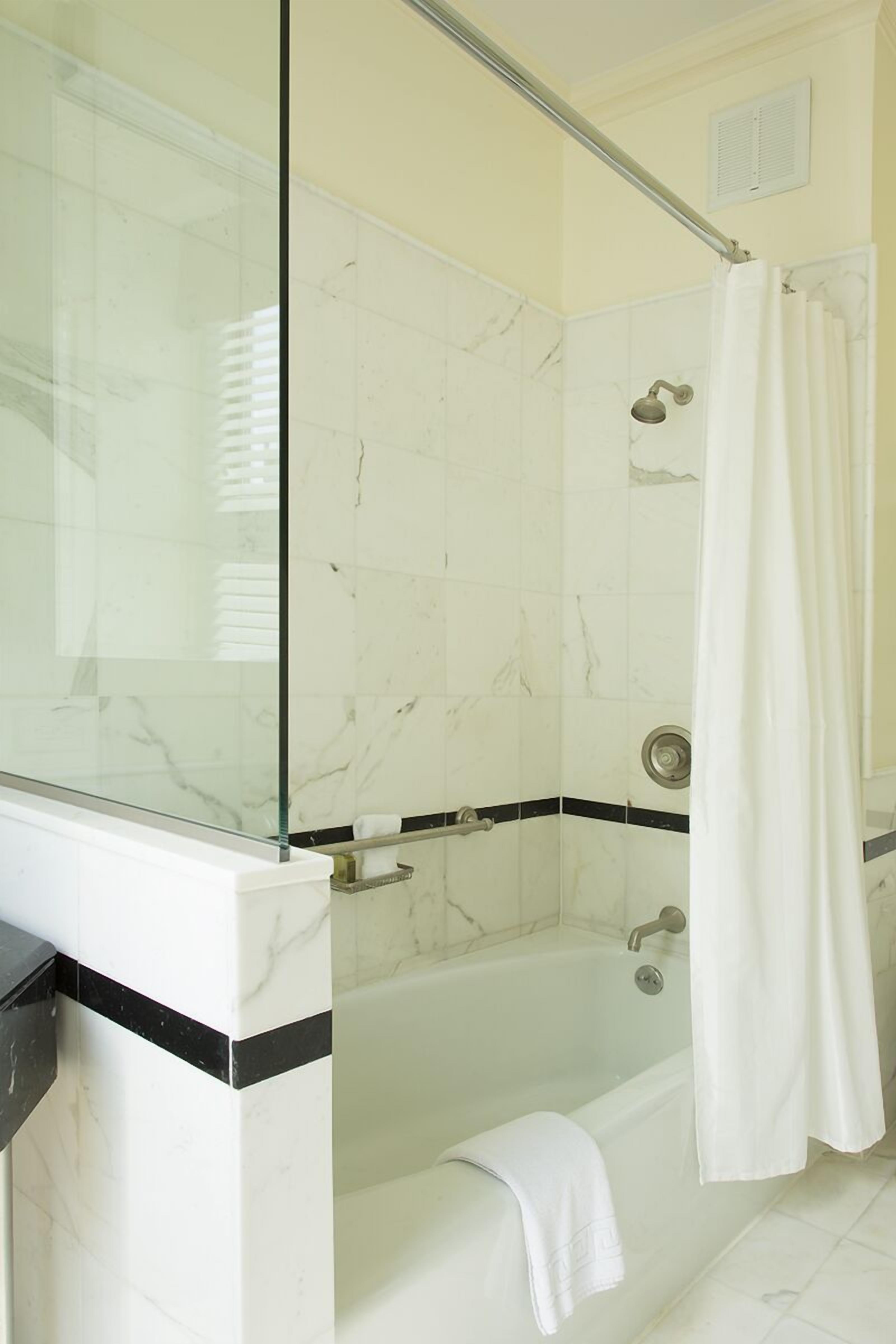 A modern bathroom with a glass shower enclosure, a bathtub, and a glass-enclosed shower area.