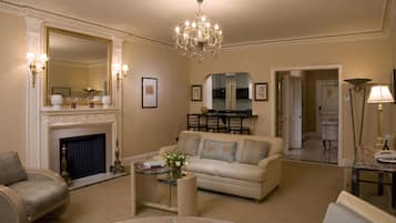 A spacious living room with a fireplace, a chandelier, and a dining area.