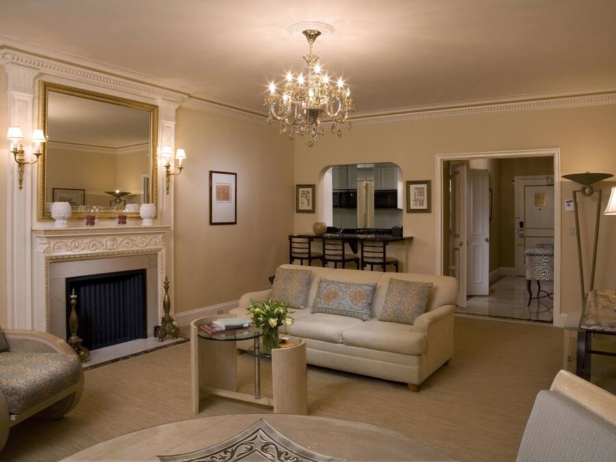A spacious living room with a fireplace, a chandelier, and a dining area.