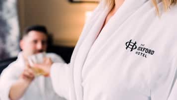 Una persona con una bata blanca y el logotipo de "The Oxford Hotel", lo que sugiere un entorno hotelero.